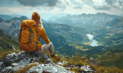Gordijnen A hiker with a backpack relaxes at the mountain's peak, taking in the breathtaking valley view, embodying the spirit of outdoor adventure. © Igal