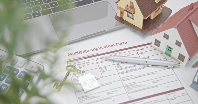 Mortgage loan or home equity loan, financial concept : Model residential house on a mortgage application form, depicting home loan or borrowing money to purchase a new home for first time homebuyer.