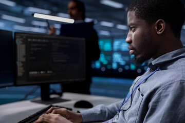 Computer scientist reconfiguring server room to optimize it for data processing requirements of customers. Programmer typing on PC, ensuring data center equipment operates efficiently, close up