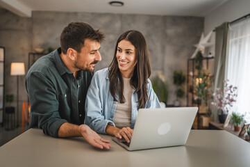 adult caucasian couple stand and use, study learn on laptop at home