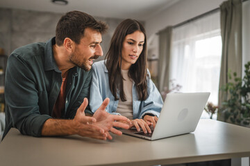 adult caucasian couple stand and use, study learn on laptop at home