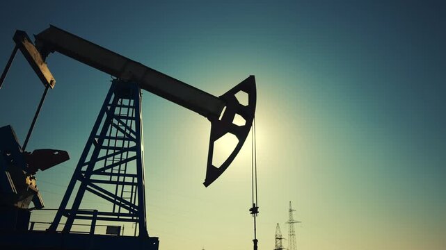 oil industry. silhouette of an oil pump lifestyle extracts oil and gas from ground of the field. business industry concept. pump pumps oil and gas at sunset. drill petroleum middle sunlight industry