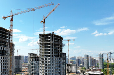  onstruction site with tower cranes on building construction. Builder on formworks. Cranes on pouring concrete in formwork. Tower cranes on construction in built environment. Buildings renovation.