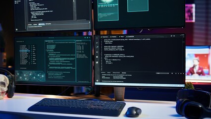 Close up of code running on computer displays in empty apartment used by hacker stealing secrets....