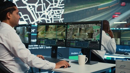 Team of employees monitoring delivery trucks with gps coordinates on satellite navigation, tracking orders with awb shipping system. Operators working in control center. Camera B.