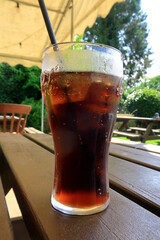 A cold glass of cola on a hot sunny day