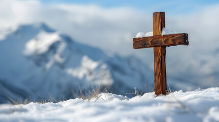 Wooden Christian cross in the snow with snowy mountains in the background and copy space.