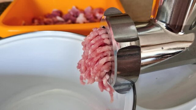 Meat grinder machine chopping uncooked ground meat. Mincing-machine and the forcemeat.