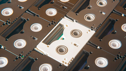 old black mini DV cassettes surrounding a white cassette