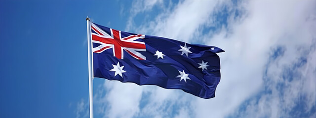 Australian flag fluttering in the wind against a blue sky, Australia, flag, wind, patriotic, symbol.