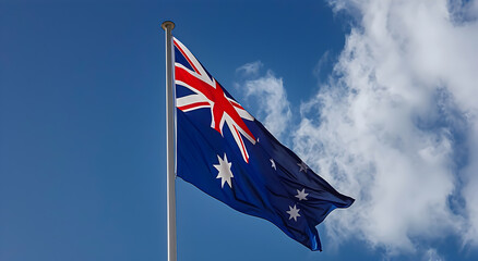 Obraz premium Australian flag fluttering in the wind against a blue sky, Australia, flag, wind, patriotic, symbol.