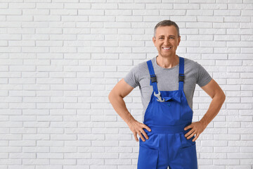 Portrait of male mechanic on white brick background