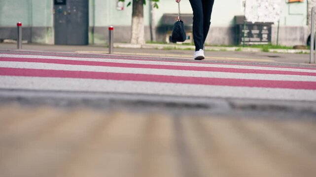 on road pedestrian crossing red and white stripes close-up of legs in white beauties crossing the road safe movement