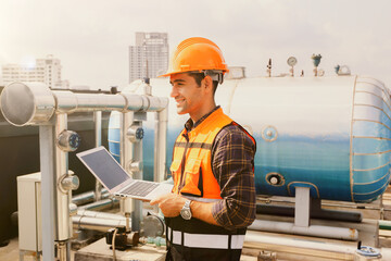 Portrait male HAVC refrigeration system technician holding laptop preventive inspection...