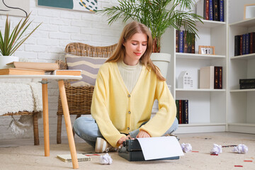 Female author typing on vintage typewriter at home