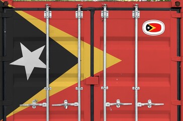 Timor Leste flag depicted on metal doors of shipping cargo container outdoors in docks area close up