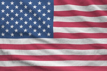 United States of America flag depicted on folded wavy fabric of old cloth close up