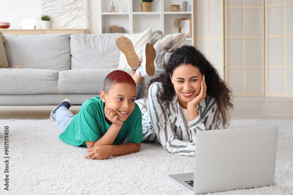 Canvas Prints Little African-American boy with his mother watching cartoons on floor at home