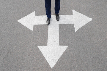 Businessman standing on road with arrow marking. Concept of career choice