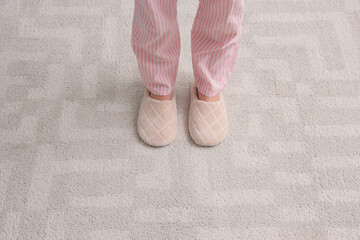Woman in slippers standing on soft carpet. New beginning concept
