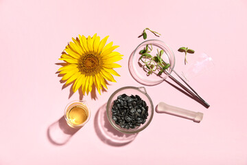 Petri dishes with sunflower, seeds, oil and sprouts on pink background