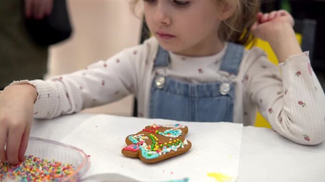 A child joyfully decorating a Christmas gingerbrea