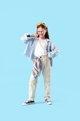Little girl with microphone singing on blue background