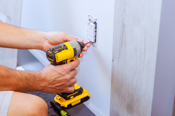 Installing an outlet with screwdriver in house during reconstruction