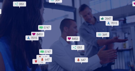 Image of social media notifications over caucasian colleagues talking at office