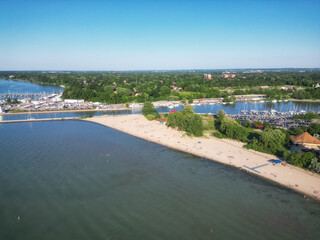 Obraz premium Aerial over Lakeside Park Beach in the Port Dalhousie area of St. Catharines, Ontario, Canada, on the south shore of Lake Ontario, with Martindale Pond. Shot on a summer afternoon in July, 2024.