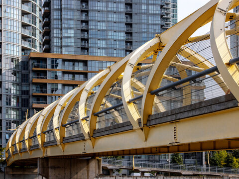 A steel beam bridge in Toronto from Front Street over the railway tracks downtown appearing as a reminder of the heavy industry that one covered to area that is now mainly condo buildings
