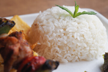 Closeup of a plate featuring white rice, French fries, and a fork, creating a delicious meal