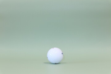 Isolated photo of a golf ball on a turquoise green background