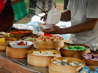 street food vendor put out various dim sums from bamboo trays for customers