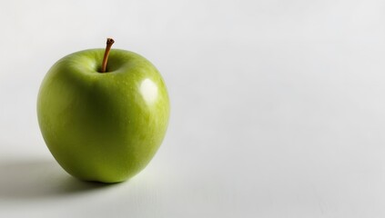 A single green apple with a leaf on a white background, the apple is smooth and shiny, and the leaf is green and vibrant