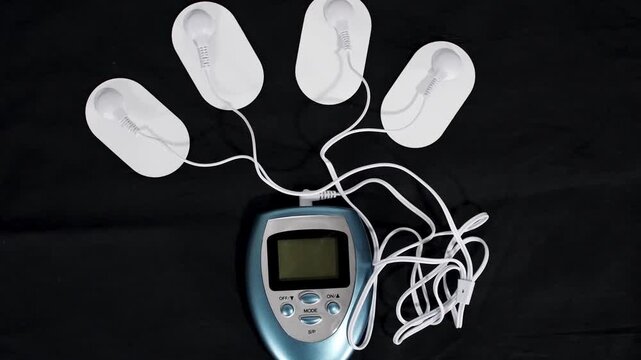 Electric massage procedure in physiotherapy, Electrical frequency therapy, alternative medicine Electrotherapy, electrical stimulation using surface electrode pads, Transcutaneous nerve device closeup