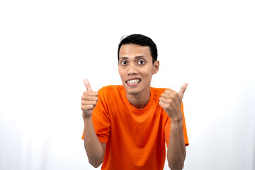 Portrait of a young Asian man wearing an orange t-shirt giving a thumbs up, okay, agree sign....