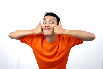 Portrait of a young Asian man wearing an orange t-shirt giving a thumbs up, okay, agree sign....