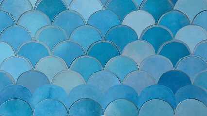 Fototapeta premium Blue tile wall with fish scale pattern.