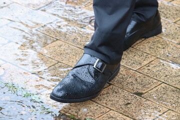 雨の中を歩く日本人ビジネスマンの足