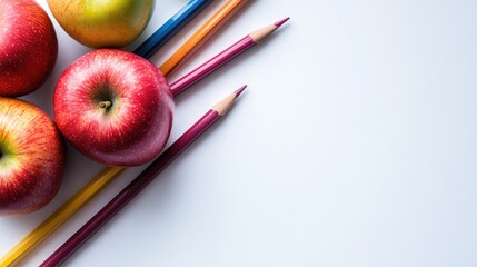 Naklejka premium Colorful Apples and Pencils on White Background Healthy Snacking and Creativity