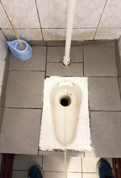 Man urinating. Tream of urine drops from height in toilet bowl. Man peeing to toilet bowl in Public toiletroom. Man pee on toilet. Standing peeing in a bowl. Urinating, peeing, pee and pissing in wc