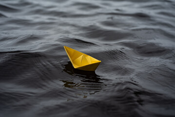 Farbiges Paierschiff auf einem See in den Wellen