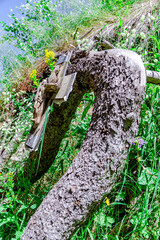 An underground church near the high-mountain skating rink Medeo in Almaty, Kazakhstan. Close up of a christian cross on a corug tree with a lot of grass and greenery