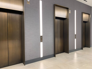 View of elevator doors with illuminated LED  lop panels in office building.