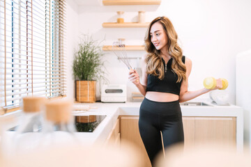 smiling woman holding cooking exercising tool in kitchen. woman control diet and workout training for body. pretty asian woman suggest eating smart food and exercising for healthy lifestyle concept