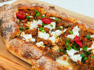 Pie open pide with beef and feta cheese close-up