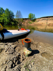 A serene boat is peacefully resting by the tranquil river shore, surrounded by the beauty of water,...