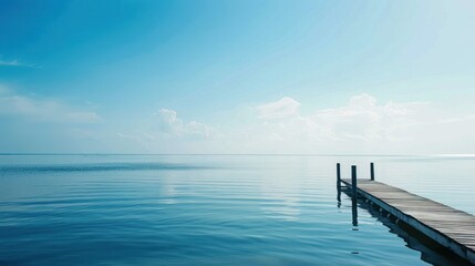 Obraz premium Wooden dock extending into calm blue waters.