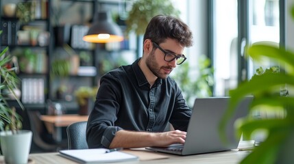 Focused professional working on a laptop at a modern office desk with a sleek workspace environment, perfect for business and technology-themed projects or corporate lifestyle concepts